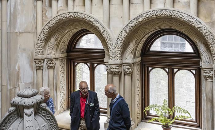 Volunteer talking to visitors on the carved Grand Staircase at Penrhyn Castle
